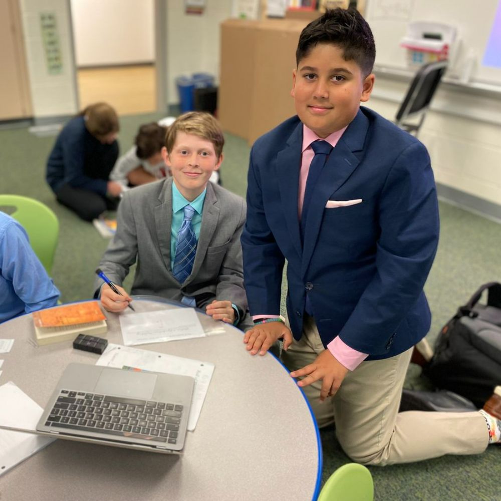 two boys wokring together at a desk