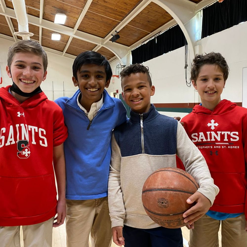 Photo of a group of students. One is holding a basketball